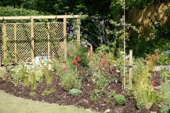 Large garden with patio, covered seating and large flower beds